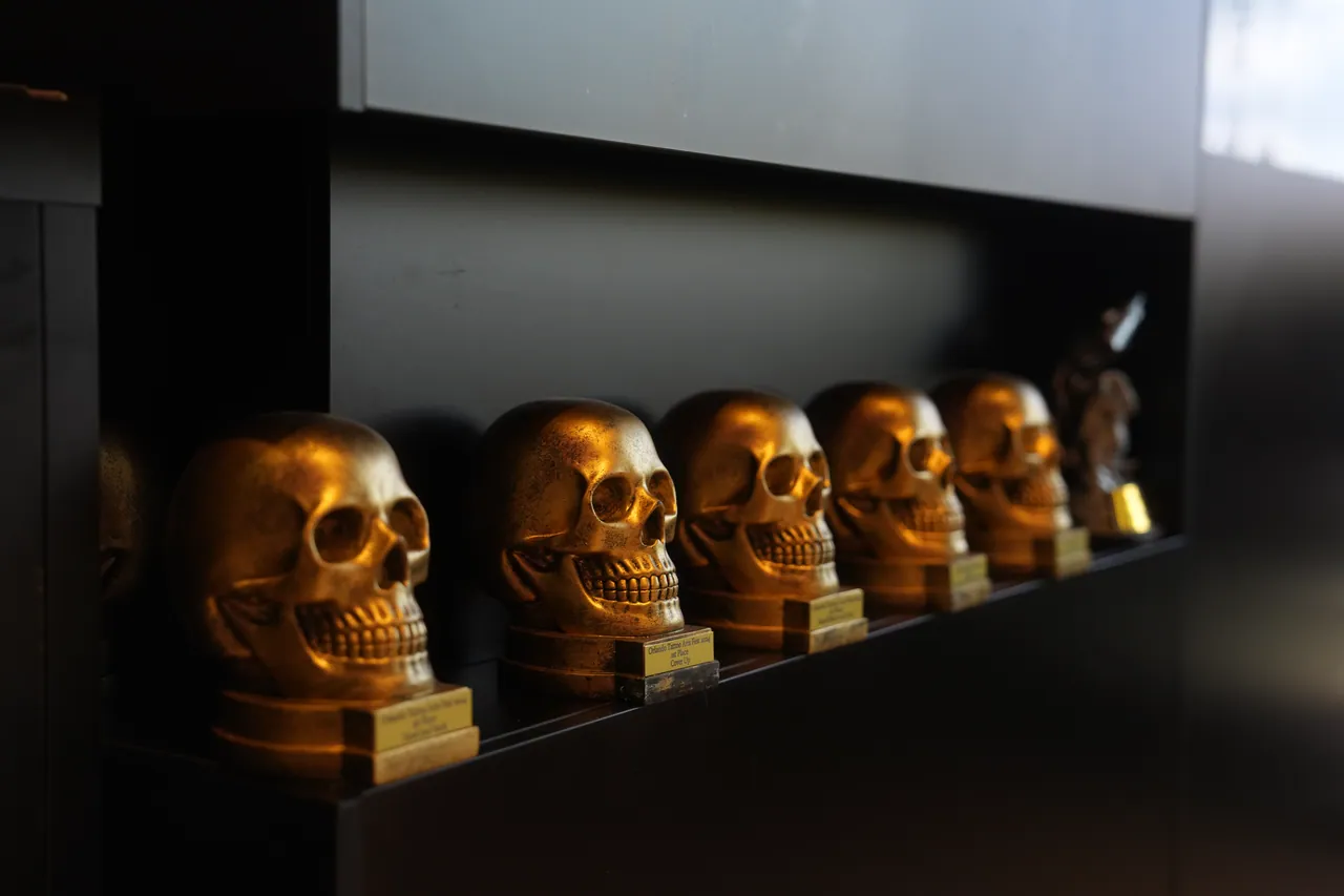 A row of gold skulls on a black shelf