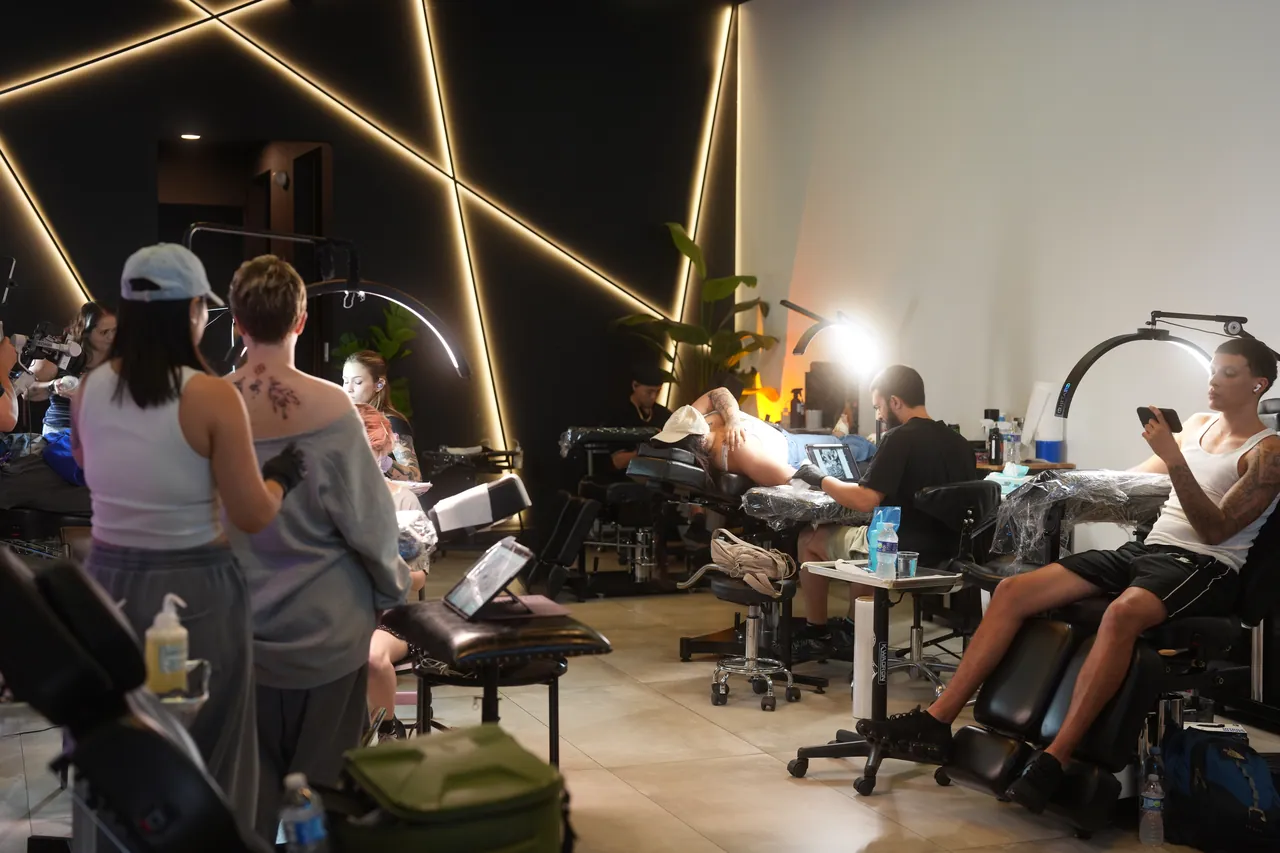 Artists at work on the studio floor under crossed light bars